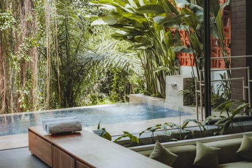 a pool in the middle of a room with plants at Moon Rock Villas Ubud by Ribas in Gianyar