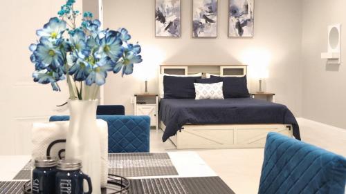 a bedroom with a bed and a vase with blue flowers at Blue Dream Sunrise - Your journey, our passion in Lakeland
