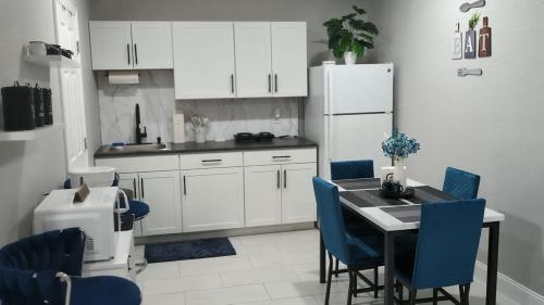 a kitchen with a table and chairs and a refrigerator at Blue Dream Sunrise - Your journey, our passion in Lakeland