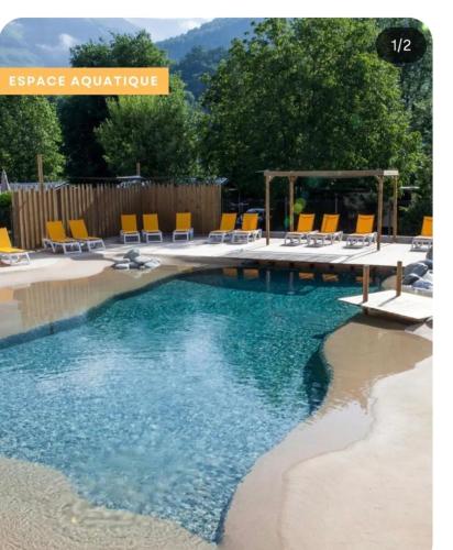 a swimming pool with lounge chairs and a swimming pool at Cabane bois insolite vue montagne piscines famille in Laruns