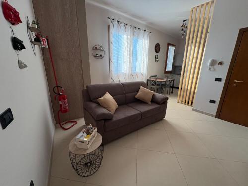 a living room with a brown couch and a table at Dimora Porta Vicenza-Montagnana in Montagnana