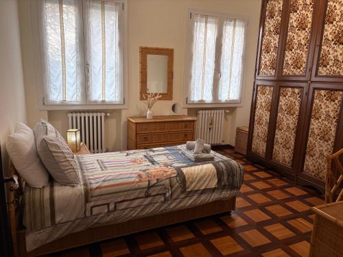 a bedroom with a bed and a dresser and windows at Villa Magnolia in Vicenza