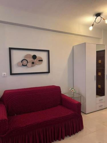 a red couch in a living room with a picture at Velvet studios Ioanna in Naousa