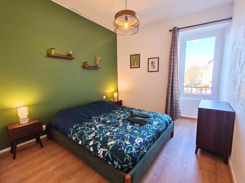 a bedroom with a bed and a green wall at Ressource in Casteljaloux