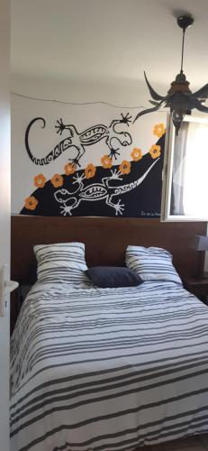 a bedroom with a bed with a black and white comforter at Chez domi piscine résidence claire rive in Prayssac