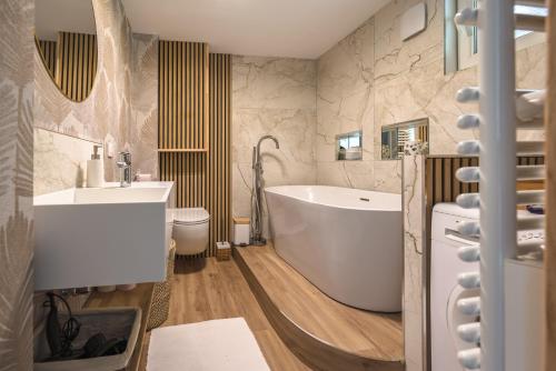 a bathroom with a tub and a sink at Cocon des dunes in Camiers