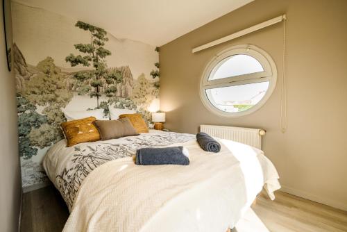 a bedroom with a large bed with a window at Cocon des dunes in Camiers