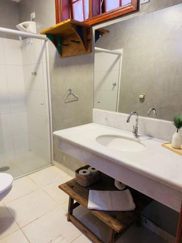 a bathroom with a sink and a shower at Jeromia Casa e Pousada in Rifaina