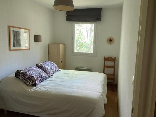 a bedroom with a white bed with pillows on it at T2 tout confort Ax les thermes in Ax-les-Thermes