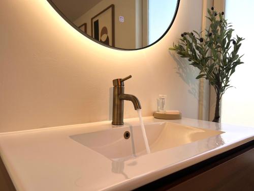 a bathroom sink with a faucet and a mirror at Santos in Noordwijk aan Zee