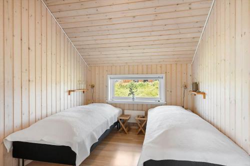 two beds in a room with a window at 392-Harboore-Fourmivej-64 in Harboør
