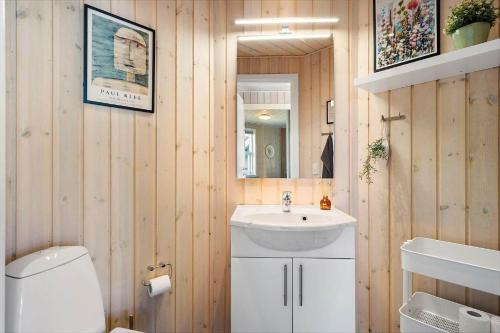 a bathroom with a sink and a toilet and a mirror at 392-Harboore-Fourmivej-64 in Harboør