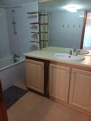 a bathroom with a sink and a mirror at Charmant studio au rez de chaussée in Arbois