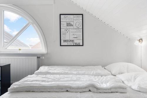 a white bedroom with a bed and a window at 0457-Romo-Vestergade-119-App-57 in Høm