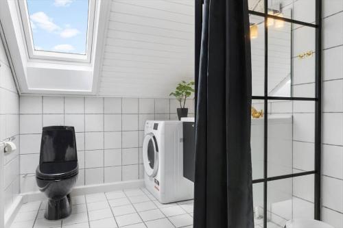 a bathroom with a toilet and a window at 0457-Romo-Vestergade-119-App-57 in Høm