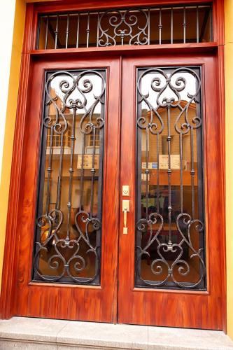 a wooden door with two windows in a building at Hotel PREMIER in Linares
