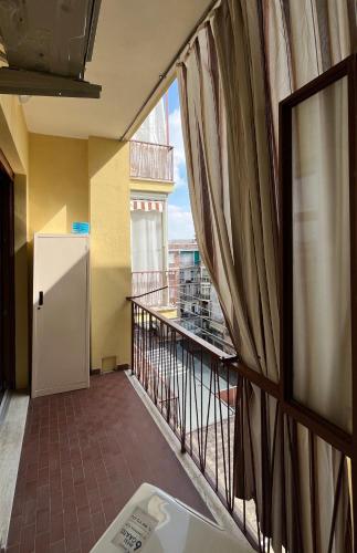 a room with a balcony with a refrigerator at Alloggio Manzoni in Asti