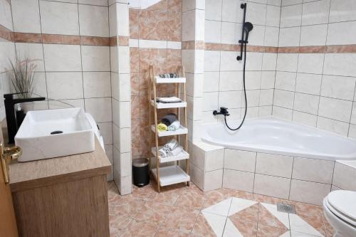 a bathroom with a tub and a toilet and a sink at Apartman Lucija in Selce