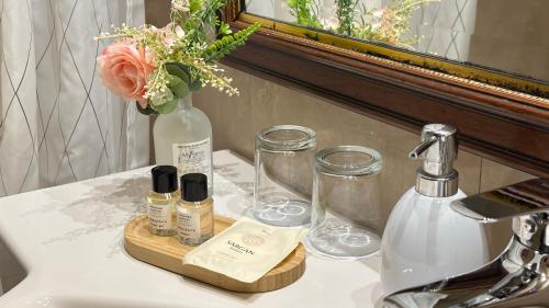 a bathroom sink with a bottle of perfume and a vase at FLEUR DE LIS HOTEL in Prague