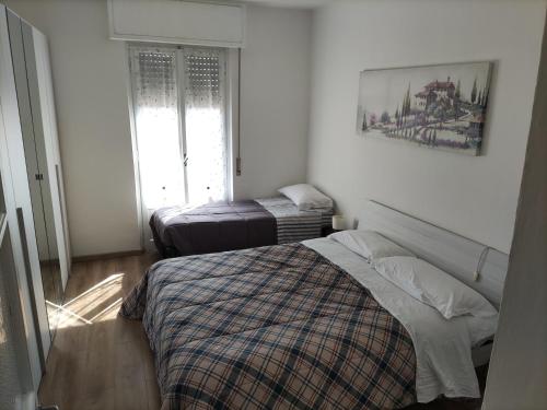a bedroom with a bed and two ottomans at Brunate Funicolare Apartament in Brunate