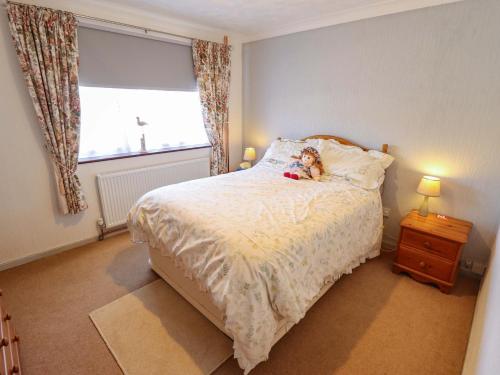 a bedroom with a bed with a teddy bear on it at Seascape in Hunstanton