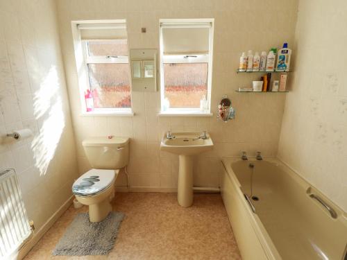 a bathroom with a toilet and a sink and a tub at Seascape in Hunstanton