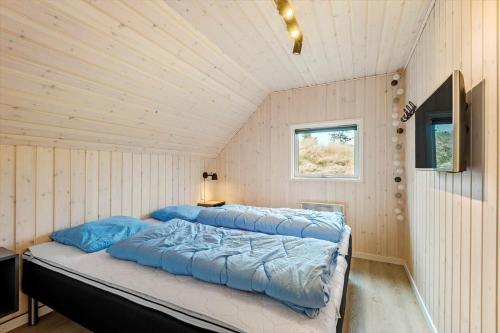a bedroom with a bed in a room with wooden walls at 0218-Romo-A-Hveyselsvej-13 in Høm