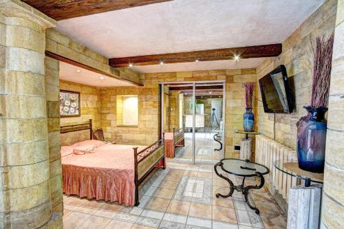 a bedroom with a bed and a table and a tv at Villa da Winci in Odesa