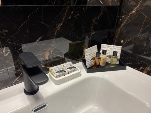 a white bathroom sink with a faucet and complimentary products at B&B Da Vinci in Cassano delle Murge