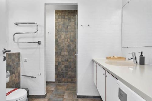 a bathroom with a shower and a toilet and a sink at 1165-Romo-Gulirisvej-841 in Høm