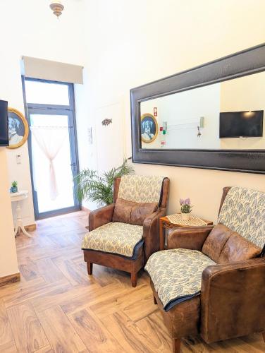 a living room with two chairs and a mirror at Charming Portuguese style apartment, for rent "Vida à Portuguesa", "Fruta or Polvo" Alojamento Local in Portimão