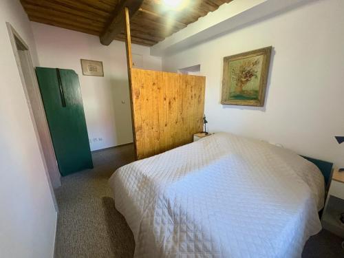 a bedroom with a white bed and a green door at Bendovský dvůr in Dušníky