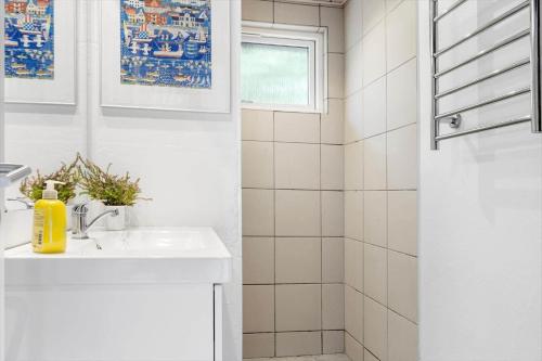 a white bathroom with a sink and a shower at 0167-Romo-Julianehab-12 in Høm