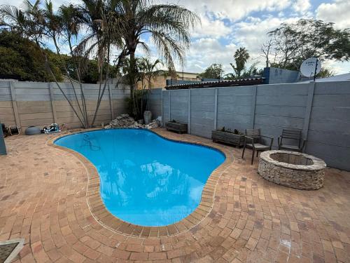a swimming pool on a brick patio with a fire pit at Blue Moon Charming 2 Bed Poolside Apartment in Bellville