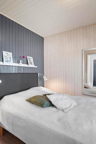a bedroom with a white bed with a pillow on it at 0421-Romo-Vestergade-3-Ap-34 in Høm
