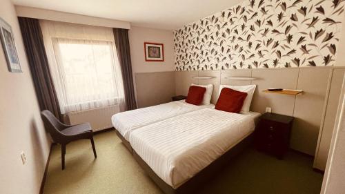 a hotel room with a bed and a window at Hotel Heynen in Valkenburg