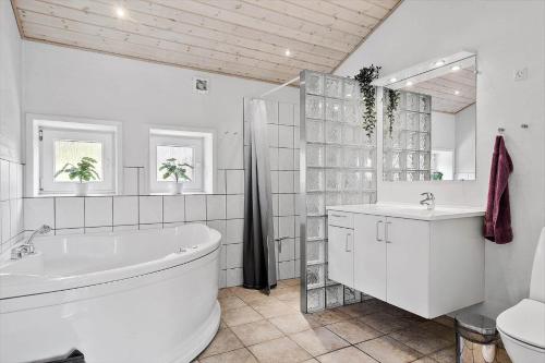 a white bathroom with a tub and a sink at 0403-Romo-Lyngvejen-44-C in Høm