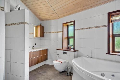 a white bathroom with a tub and a toilet at 0335-Romo-Vestergardsvaenget-2 in Høm