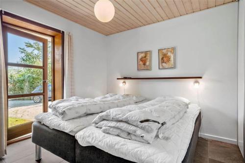 a group of four beds in a room with a window at 0335-Romo-Vestergardsvaenget-2 in Høm