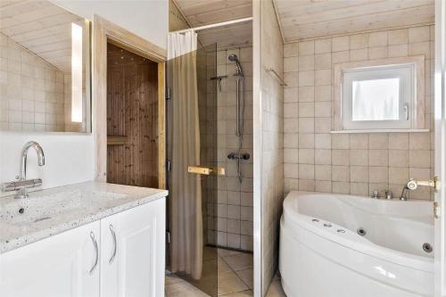 a bathroom with a tub and a sink and a shower at 0049-Romo-Magevej-5 in Høm
