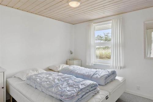 a white bedroom with a bed and a window at 0049-Romo-Magevej-5 in Høm