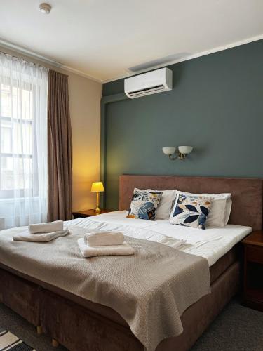 a bedroom with a large bed with two towels on it at Apple Economy Hotel in Kaunas