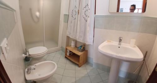 a bathroom with a toilet and a sink at Sunset House in Mortigliano