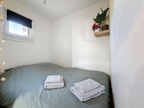 a small room with two towels on a bed at Cocon Cosy in Carnon-Plage