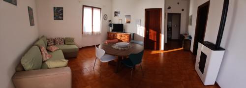 a living room with a couch and a table at Sunset House in Mortigliano