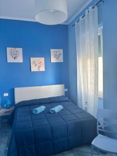 a blue bedroom with a bed with blue walls at Tower casa vacanze 2 in Anzio