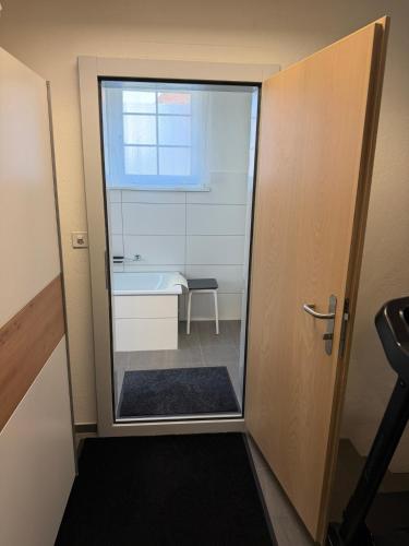 a bathroom with a glass door and a bath tub at Gästehaus Eichberg, Rheintal in Eichberg