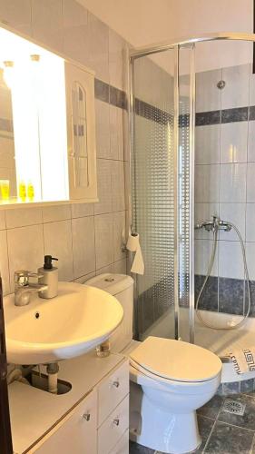 a bathroom with a sink and a toilet and a shower at Sweet Studio in Leptokarya