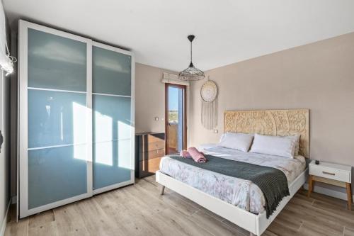 a bedroom with a bed and a glass wall at Ca Marga in Santa Pola