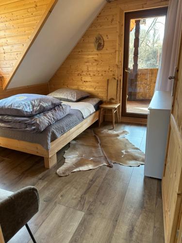 a bedroom with a bed in a wooden cabin at Bieszczady ClaraArt in Czarna